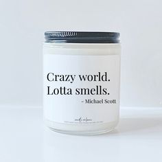 a candle with a quote on it that says, crazy world lotta smells michael scott