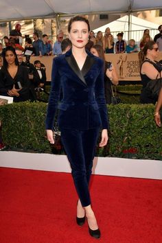 a woman in a blue velvet suit and black heels on the red carpet at an event