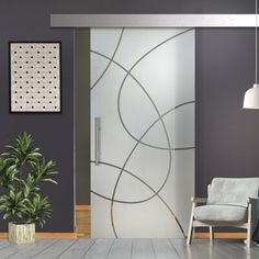 a living room with a chair, potted plant and glass door