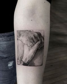 a woman's arm with a black and white photo of a hand holding a horse