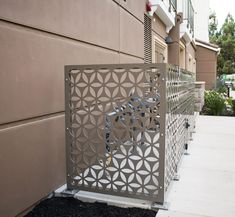 a metal gate on the side of a building with flowers and leaves carved into it