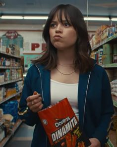 a woman holding a bag of food in a store