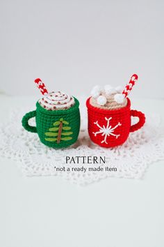 two crocheted mugs with hot chocolate and marshmallows in them