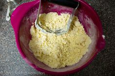 a pink bowl filled with food and a whisk in it