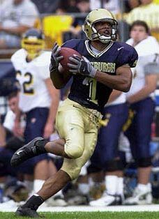 a football player running with the ball in his hands and people watching from the stands behind him