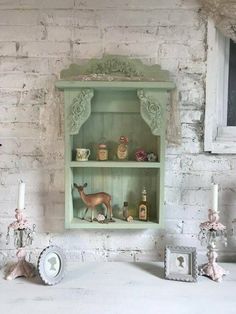 an old fashioned shelf with deer figurines and other items on it in front of a brick wall