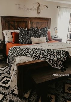 a bed with black and white pillows on it