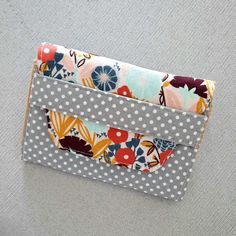 a wallet is sitting on the floor with polka dots and colorful fabric in it's pocket