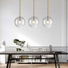 three lights hanging from the ceiling above a table