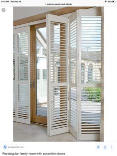 a room divider made out of shutters in front of a window with an open door