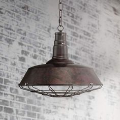 an old fashioned light hanging from a chain in front of a brick wall with white paint