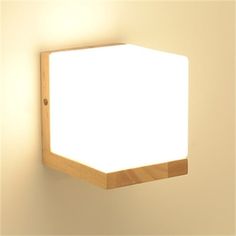 a light that is on the side of a wall with a wooden frame around it