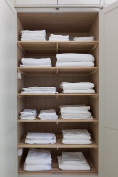 the closet is full of folded white sheets