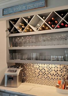 a wine rack filled with lots of bottles and glasses on top of a kitchen counter