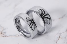 two wedding rings with spider web designs on them