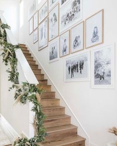 the stairs in this house are decorated with pictures and garlands on them, as well as greenery