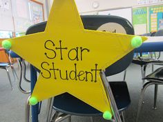 a yellow star with the words star student written on it in front of a classroom desk