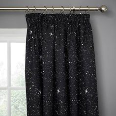 the curtain is hanging in front of a window with stars and moon print on it