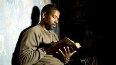 a man sitting down while reading a book