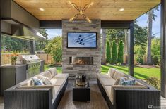 a living room with couches and a fire place in front of a large window