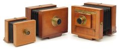 three old fashioned wooden cameras sitting next to each other