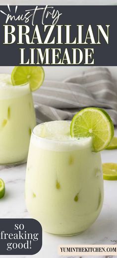 two glasses filled with limeade on top of a white marble counter next to sliced limes