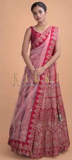 a woman in a red and pink lehenga