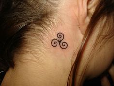 a woman with a small tattoo on her neck and behind her ear is a spiral design