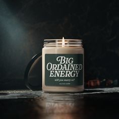 a candle is sitting on a table with the words,'big ordained energy '