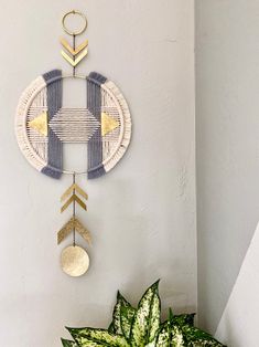 a potted plant sitting on top of a table next to a wall hanging decoration