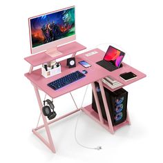 a pink computer desk with a monitor, keyboard and headphones on top of it