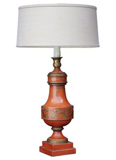 an orange lamp with a white shade on it