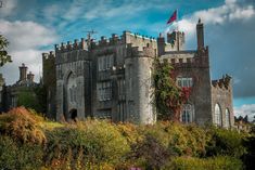 an old castle sitting on top of a lush green hillside