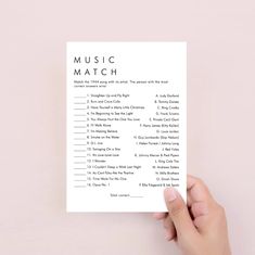 a hand holding up a music match card with the words'music'on it