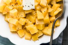 a white bowl filled with cut up pieces of fruit and topped with a dollop of cream