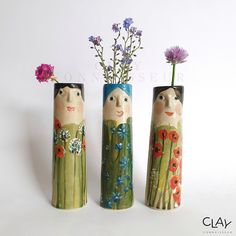 three vases with flowers in them sitting next to each other on a white surface