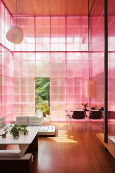 a living room filled with furniture and lots of pink glass covering the walls behind it