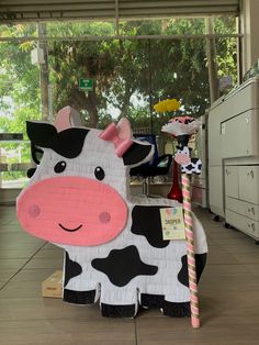 a cow made out of cardboard sitting on the floor