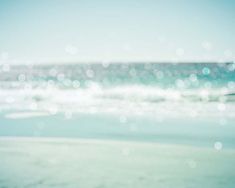 blurry photograph of the ocean and beach with blue sky in the backgroud