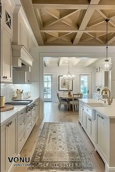 A beautifully designed farmhouse kitchen featuring exposed beam ceilings, a neutral color palette, and elegant fixtures, leading into a dining area that combines rustic charm with modern sophistication. Exposed Beams Ceiling, Low Country Homes, Warm Interior, Country House Interior