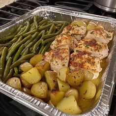 chicken, potatoes and green beans in a pan on the stove