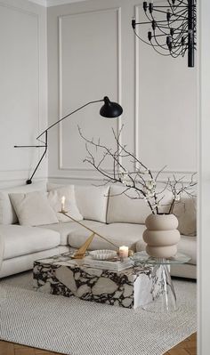 a living room with a couch, table and chandelier