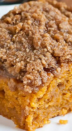 a close up of a piece of cake on a plate with crumb toppings