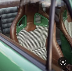 the interior of a green car with brown and white checkered leather upholstered