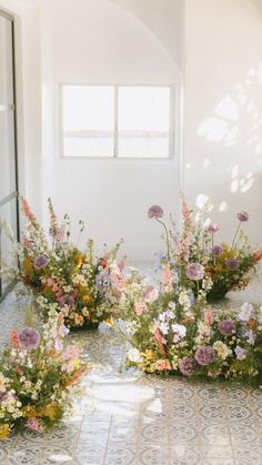 flowers are arranged on the floor in front of a window