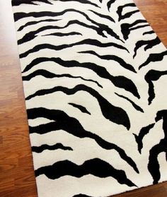 a black and white zebra print rug is on the floor in front of a wooden floor