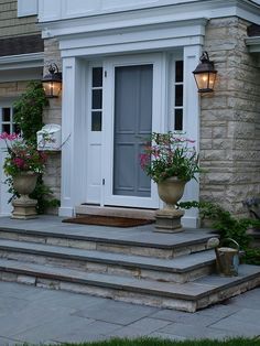 a house with two large planters on the front steps