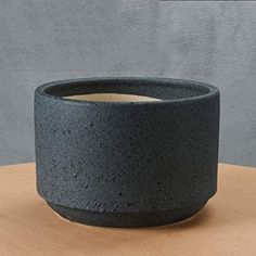 a black bowl sitting on top of a wooden table