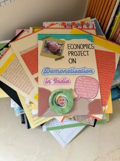 a pile of papers sitting on top of a table next to a stack of books