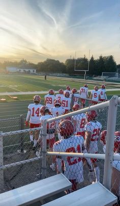 a group of young men standing next to each other on top of a football field